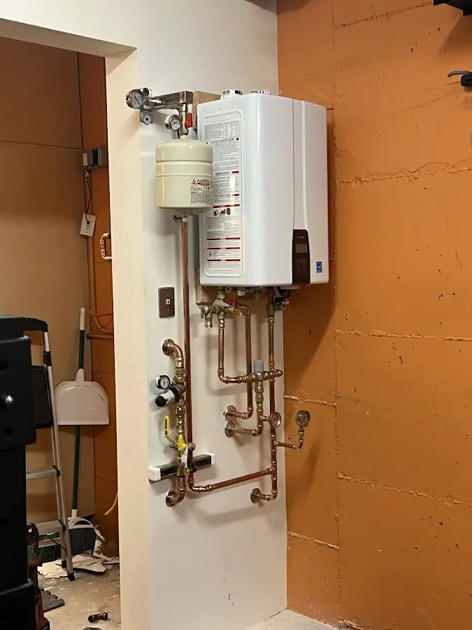 Plumbing technician inspecting water heater connections in Alloway